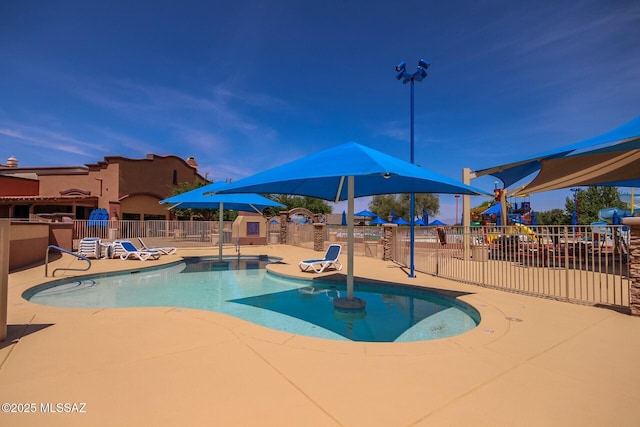 community pool with fence, a patio area, and playground community
