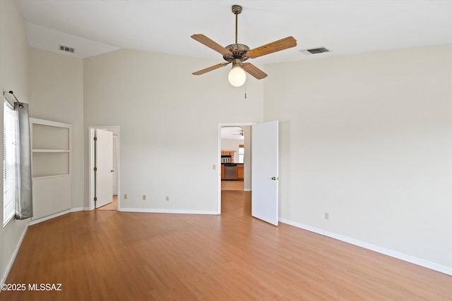 unfurnished bedroom with visible vents, light wood-style flooring, baseboards, and high vaulted ceiling