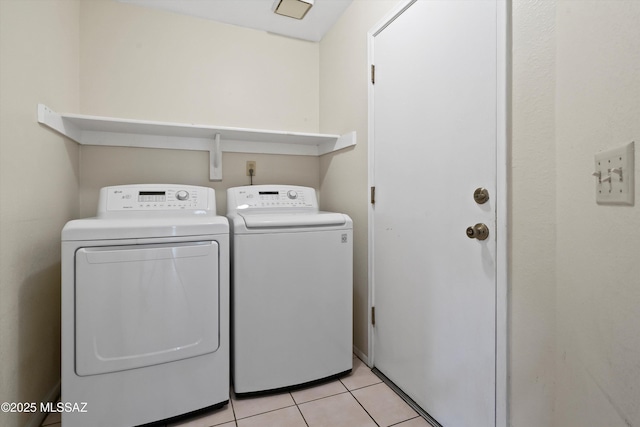 laundry area with laundry area, light tile patterned flooring, and washing machine and clothes dryer