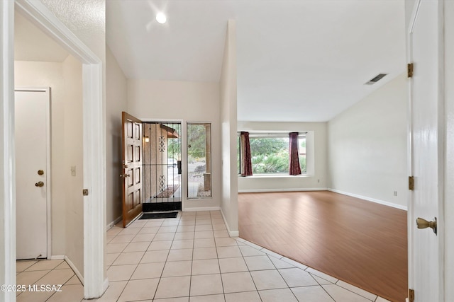 entrance foyer with baseboards, visible vents, and light tile patterned floors