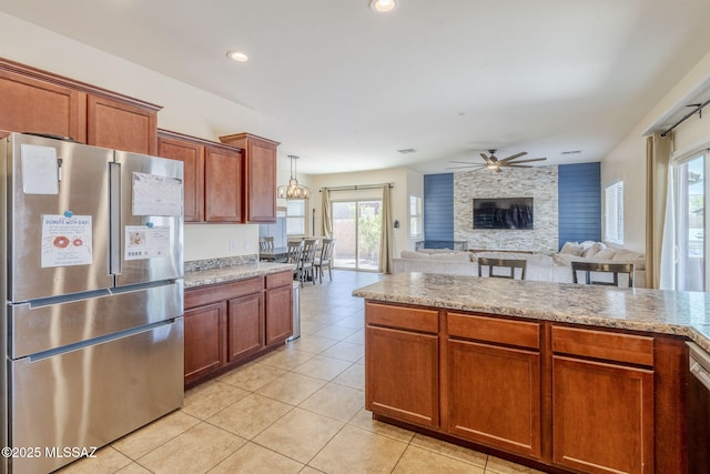 kitchen featuring light tile patterned floors, brown cabinetry, a ceiling fan, and stainless steel refrigerator with ice dispenser