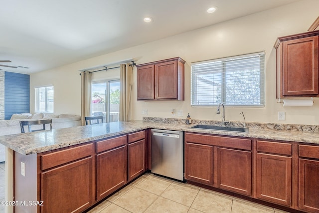 kitchen featuring a peninsula, open floor plan, light tile patterned floors, stainless steel dishwasher, and a sink