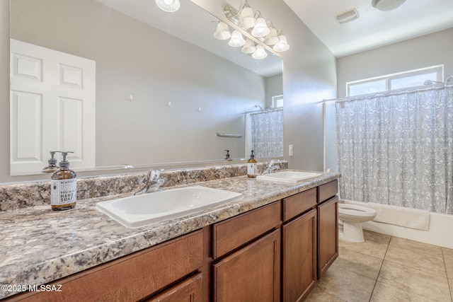 bathroom with toilet, tile patterned floors, double vanity, and a sink