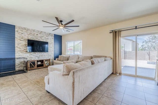 living area with light tile patterned flooring, a ceiling fan, and visible vents