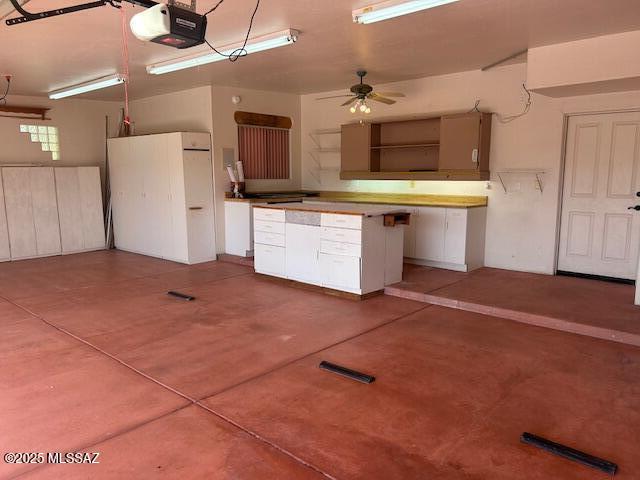 garage featuring visible vents, a ceiling fan, and a garage door opener