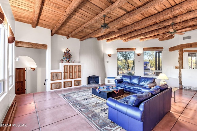 tiled living area featuring ceiling fan, arched walkways, and wood ceiling