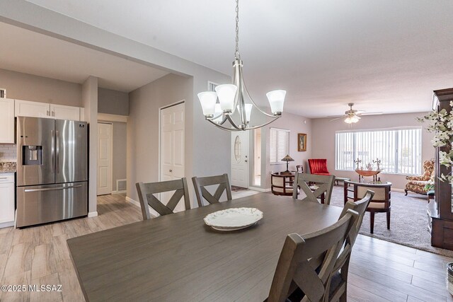 649 W Via, San Mateo, Green Valley, AZ 85614 - dining room with light wood finished floors, visible vents, ceiling fan with notable chandelier, and baseboards