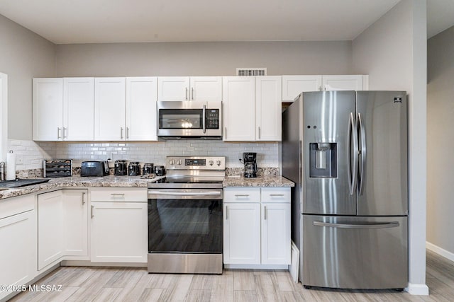 649 W Via, San Mateo, Green Valley, AZ 85614 - kitchen with light stone countertops, appliances with stainless steel finishes, backsplash, and white cabinets