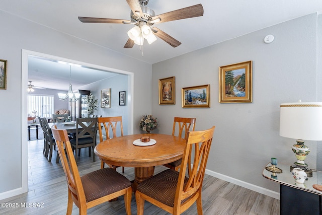 649 W Via, San Mateo, Green Valley, AZ 85614 - dining room featuring light wood-type flooring, ceiling fan with notable chandelier, and baseboards