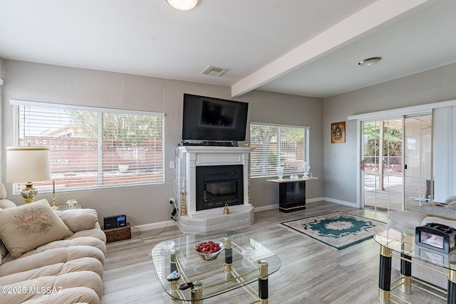 649 W Via, San Mateo, Green Valley, AZ 85614 - living room with beamed ceiling, a glass covered fireplace, visible vents, wood finished floors, and baseboards