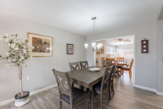 649 W Via, San Mateo, Green Valley, AZ 85614 - dining room with light wood-style flooring, baseboards, and ceiling fan with notable chandelier
