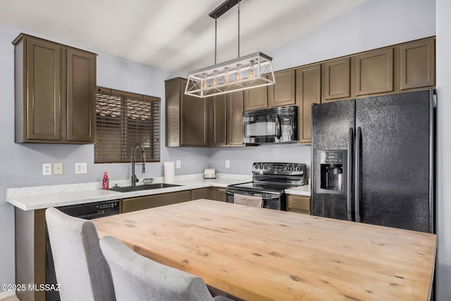 kitchen with dark brown cabinets, a sink, butcher block counters, decorative light fixtures, and black appliances