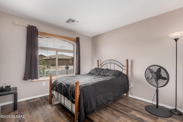 bedroom with baseboards, visible vents, and dark wood-type flooring