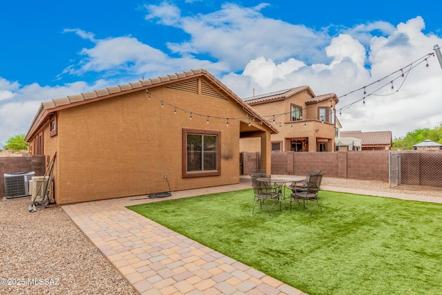 rear view of property with stucco siding, central AC unit, a tile roof, and a fenced backyard