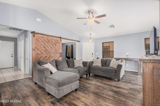 living room featuring a barn door, vaulted ceiling, visible vents, and a ceiling fan
