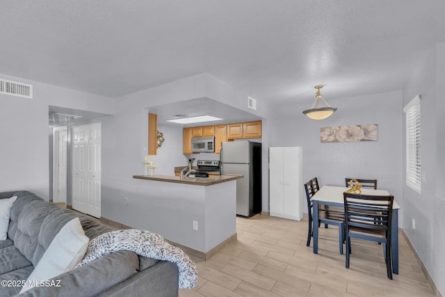 101 S Players Club Dr Unit 12103, Tucson, AZ 85745 - kitchen with light wood-style floors, a textured ceiling, visible vents, stainless steel appliances, and open floor plan