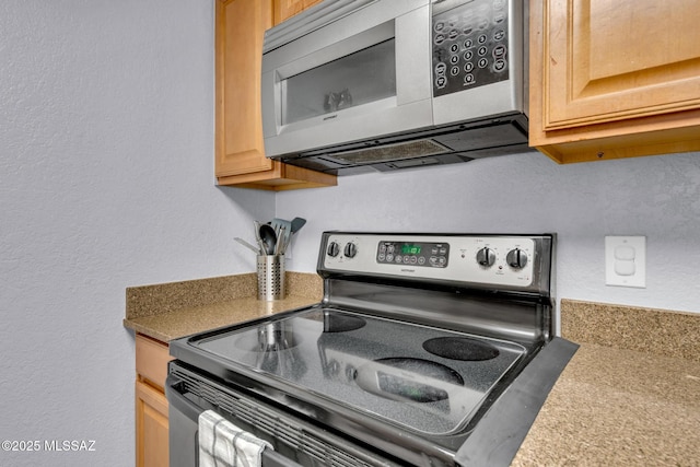 101 S Players Club Dr Unit 12103, Tucson, AZ 85745 - kitchen with a textured wall, light brown cabinetry, and appliances with stainless steel finishes