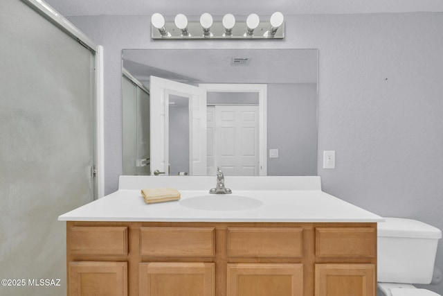 101 S Players Club Dr Unit 12103, Tucson, AZ 85745 - full bathroom featuring visible vents, toilet, a textured wall, vanity, and a stall shower
