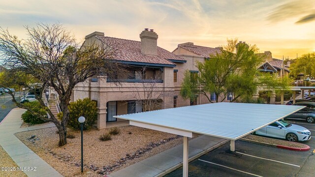 101 S Players Club Dr Unit 12103, Tucson, AZ 85745 - view of front of home featuring uncovered parking, a chimney, and stucco siding