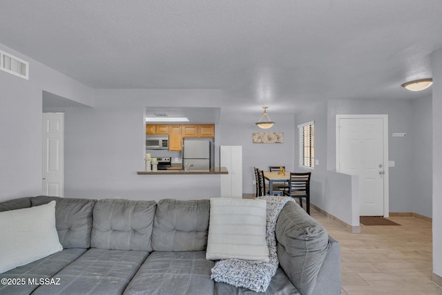 101 S Players Club Dr Unit 12103, Tucson, AZ 85745 - living area with visible vents, baseboards, and light wood finished floors