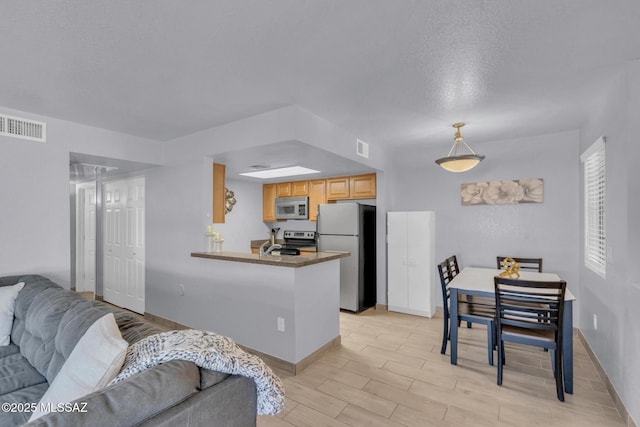 101 S Players Club Dr Unit 12103, Tucson, AZ 85745 - kitchen with light wood-type flooring, baseboards, open floor plan, visible vents, and appliances with stainless steel finishes