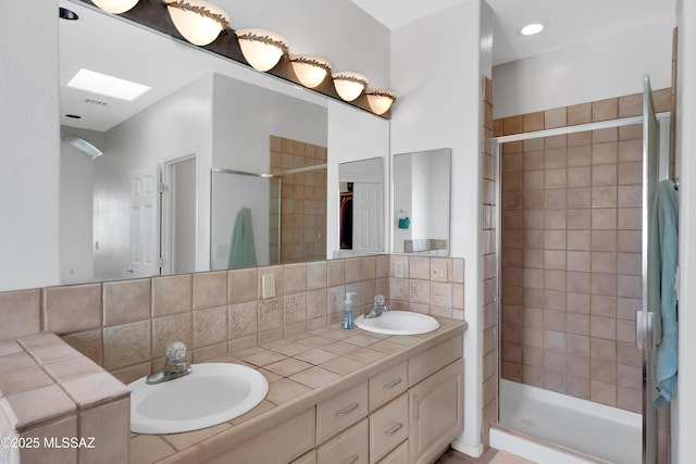 full bath featuring a shower stall, tasteful backsplash, and a sink