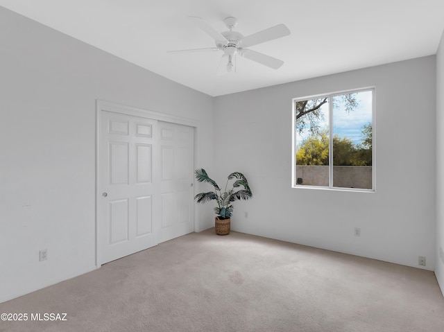 carpeted empty room featuring ceiling fan