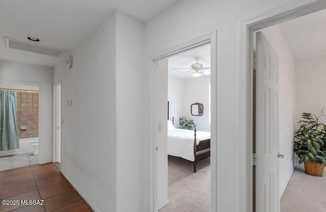 hallway with light tile patterned flooring and baseboards