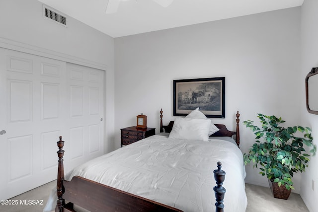 bedroom with a closet, carpet floors, visible vents, and a ceiling fan