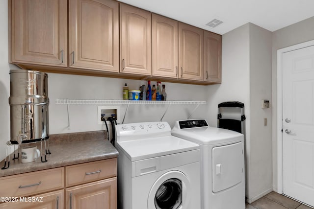 clothes washing area with cabinet space, washer and clothes dryer, visible vents, and light tile patterned floors