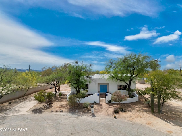 view of front of home with stucco siding and a fenced front yard