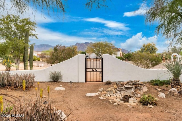 view of yard featuring a gate, fence, and a mountain view