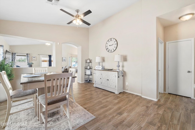dining area featuring lofted ceiling, plenty of natural light, a ceiling fan, and arched walkways
