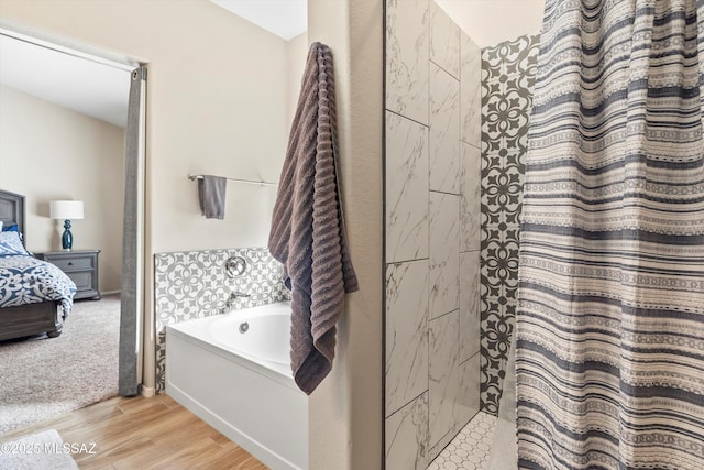 ensuite bathroom featuring a bath, ensuite bathroom, wood finished floors, and a shower with shower curtain