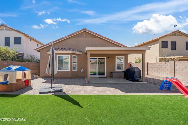back of house with a patio area, a lawn, a fenced backyard, and stucco siding