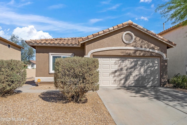 mediterranean / spanish-style house featuring concrete driveway, an attached garage, a tiled roof, and stucco siding