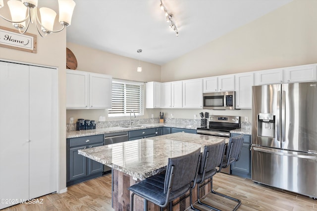 kitchen featuring a sink, white cabinetry, light stone countertops, rail lighting, and appliances with stainless steel finishes