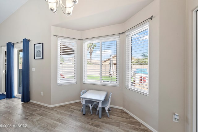 dining room featuring a wealth of natural light, a notable chandelier, wood tiled floor, and baseboards
