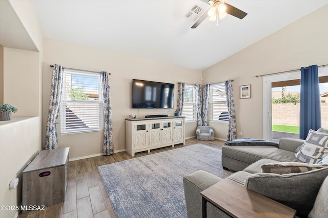 living area with baseboards, visible vents, wood finished floors, ceiling fan, and high vaulted ceiling