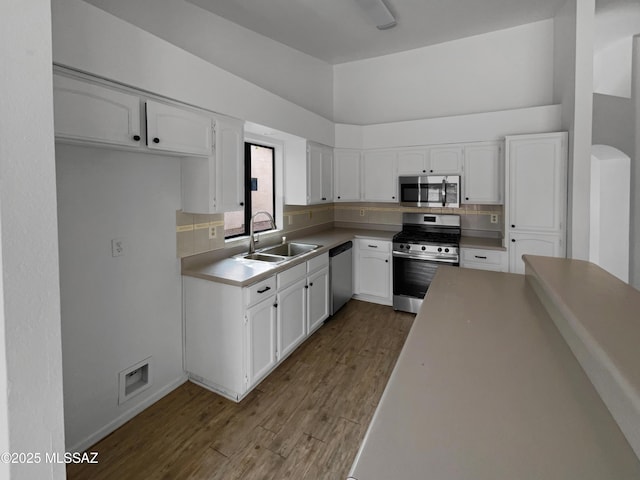 kitchen featuring dark wood finished floors, white cabinetry, a sink, and appliances with stainless steel finishes