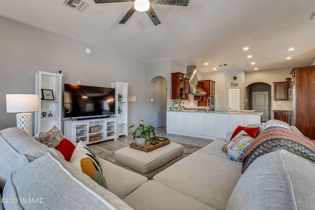 living room with visible vents, arched walkways, a ceiling fan, and recessed lighting