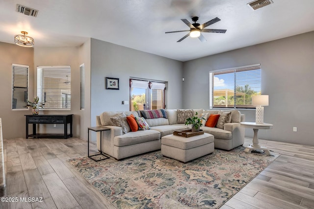 living room with visible vents, wood finished floors, and a wealth of natural light