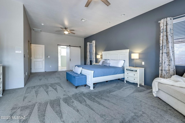 bedroom featuring visible vents, carpet flooring, a barn door, and multiple windows