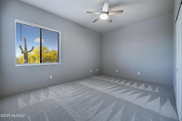 carpeted empty room featuring a ceiling fan