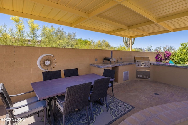 view of patio / terrace featuring area for grilling, an outdoor kitchen, and a sink
