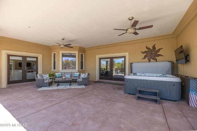 view of patio / terrace with a hot tub, a ceiling fan, french doors, and an outdoor hangout area