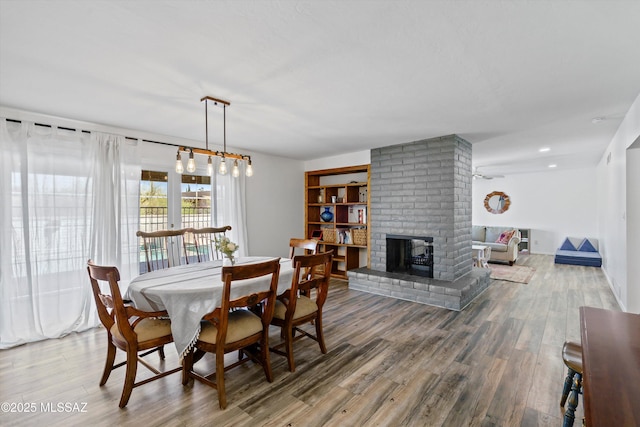 1932 W Harran Cir, Tucson, AZ 85704 - dining room with wood finished floors, a brick fireplace, and recessed lighting
