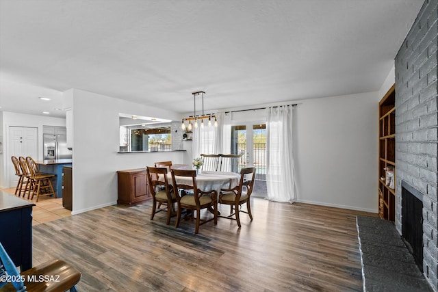 1932 W Harran Cir, Tucson, AZ 85704 - dining area with wood finished floors, a brick fireplace, baseboards, and recessed lighting
