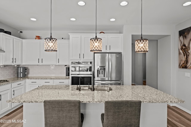 8451 N Lone Ranger Rd, Tucson, AZ 85743 - kitchen with stainless steel appliances, a kitchen island with sink, white cabinetry, recessed lighting, and dark wood finished floors