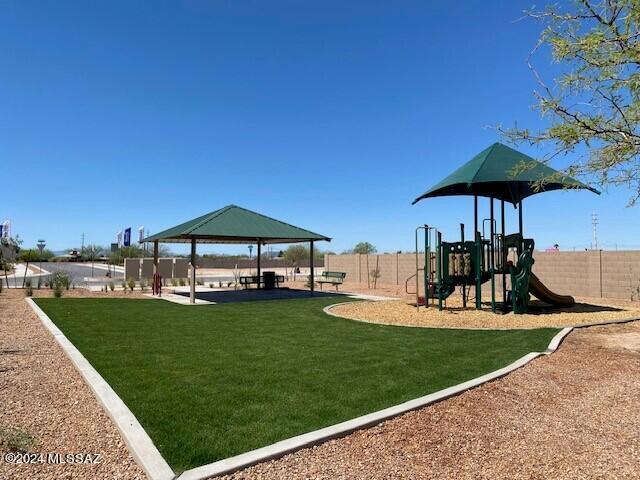 community play area featuring a gazebo, fence, and a lawn